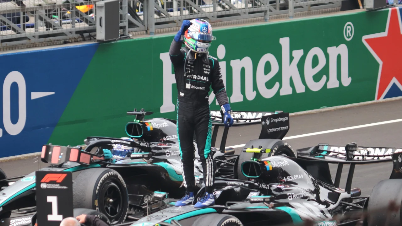 Kimi Antonelli con el uniforme de Mercedes en un circuito de Fórmula 1, de pie junto a su monoplaza.