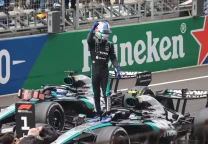 Kimi Antonelli con el uniforme de Mercedes en un circuito de Fórmula 1, de pie junto a su monoplaza.
