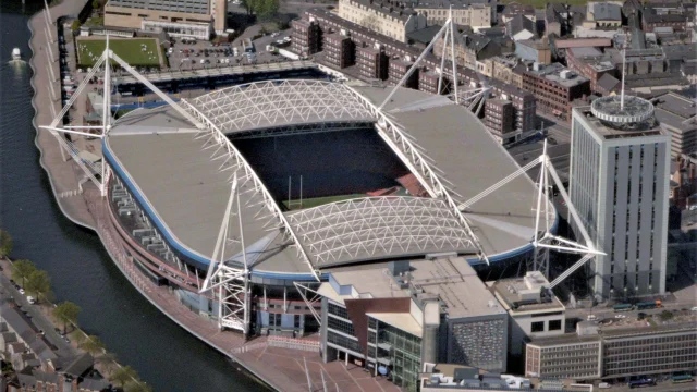 Vista aérea del Principality Stadium de Cardiff, con el techo cerrado y el campo de juego iluminado.