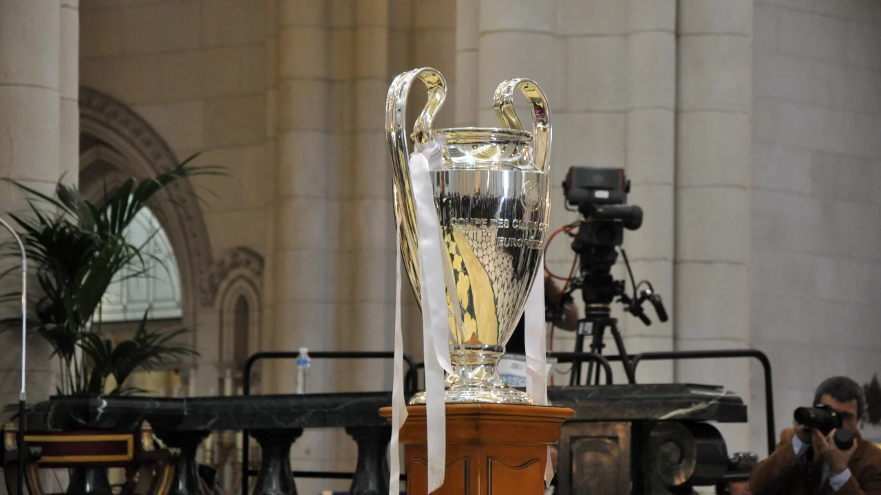 Trofeo de la Champions League sobre un fondo oscuro con luces de estadio.