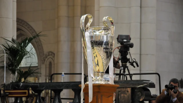 Trofeo de la Champions League sobre un fondo oscuro con luces de estadio.