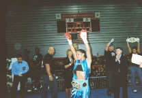 Amanda Serrano posa con los puños en alto durante una pelea de boxeo profesional.