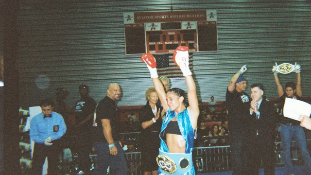 Amanda Serrano posa con los puños en alto durante una pelea de boxeo profesional.