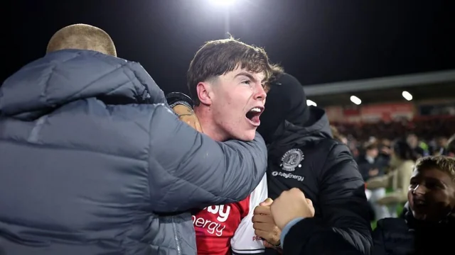 El defensor Conor Haughey celebra junto a los hinchas de Fleetwood Town tras convertir el penal decisivo ante Arsenal.