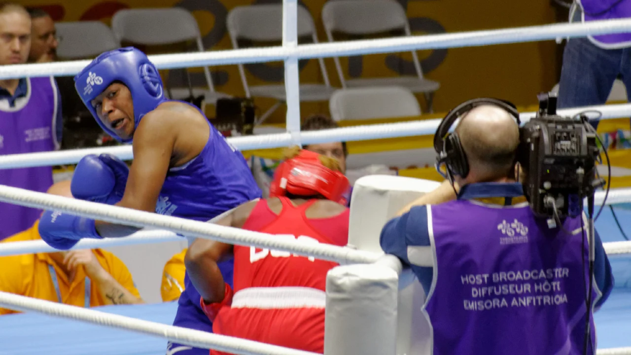 Lauren Price festeja después de una pelea con los cinturones de campeona mundial en el ring.