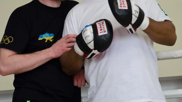 Oleksandr Usyk celebrando una victoria en el ring de boxeo.